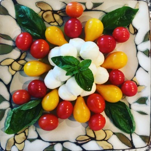 Caprese salad made with alternating red and yellow tomatoes, basil and mozzarella.